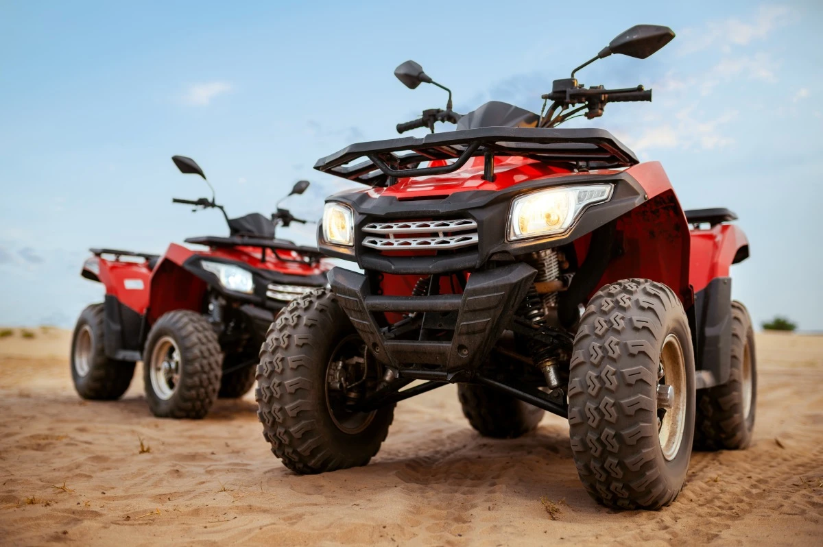 Црвени quad бајкови паркирани у пустињи при заласку сунца пре quad туре у Hurghada и Bedouin сафари авантуре